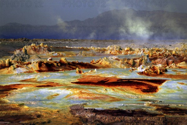 Dramatic geothermal scene in Dallol with smoke and mineral-rich rocks, Dallol, Afar region, Ethiopia