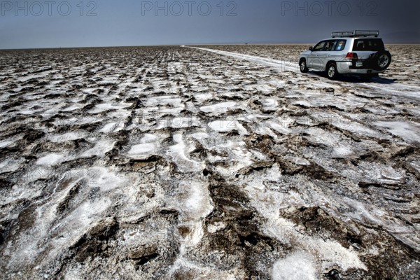 Landcruiser drives through structured salt flats, Dallol, Asale, Ethiopia