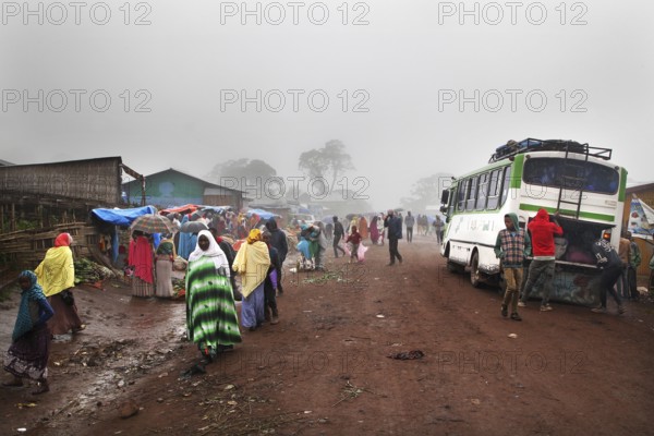 Different people and a bus on a foggy road in Rira, Rira, Bale Mountains, Ethiopia