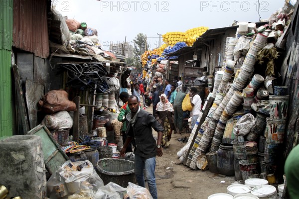Narrow market alleyway full of people and stacked pots on the Mercato in Addis Ababa, Addis Ababa, Ethiopia