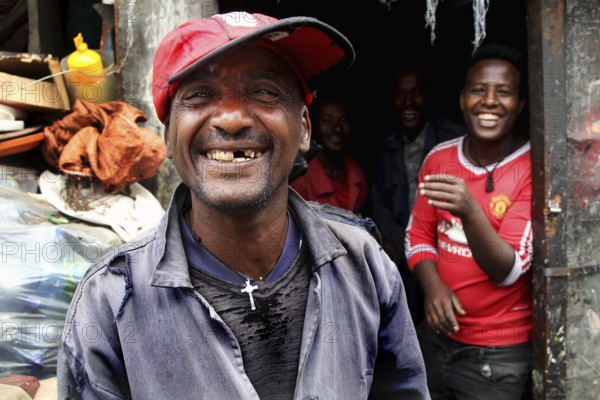 Happy people laugh in front of a shop in the Mercato of Addis Ababa, Addis Ababa, Ethiopia