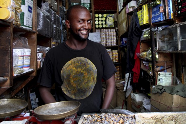 A friendly salesman stands in his shop full of spices in Mercato, Addis Ababa, Ethiopia