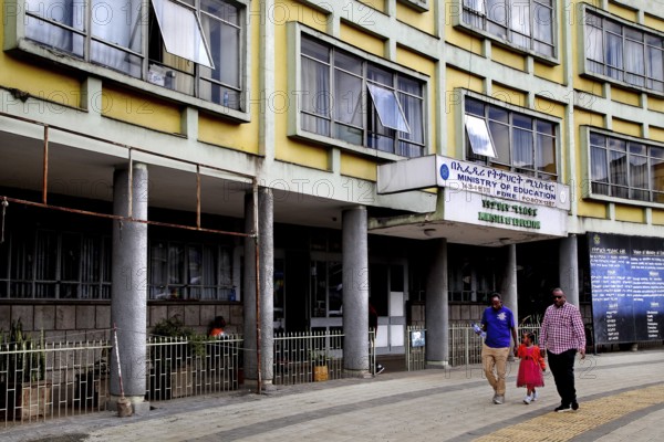 People stroll in front of an office building on an urban street, Addis Ababa, Ethiopia