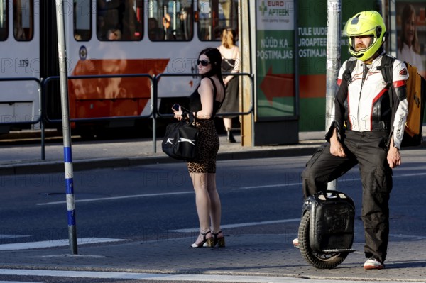 Person on electric scooter with helmet waiting at traffic lights on the road, Tallinn, South Alinn, Estonia