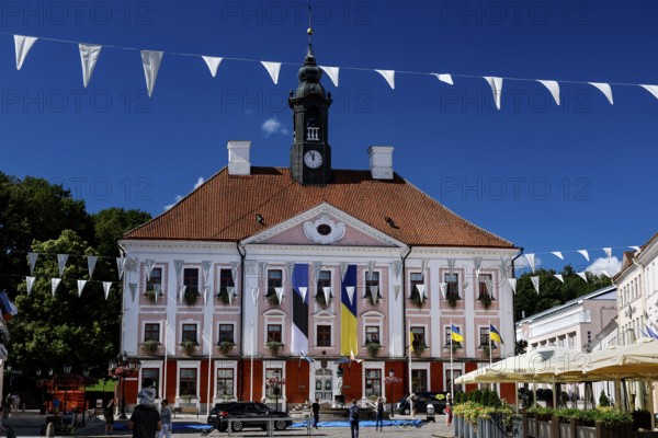 Impressive Tartu City Hall with red roof and flags on lively Town Hall Square, Rathausplatz, Rathausplatz, Tartu, Estonia