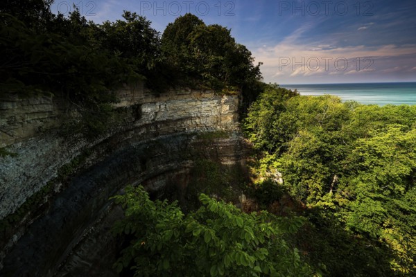 Valaste cliffs with lush vegetation and blue sea in the background, Valaste, Estonia