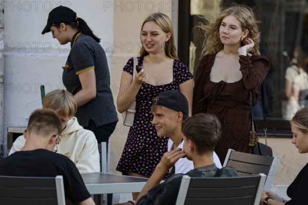 Young people relax and enjoy the sunny atmosphere on the street, Tallinn, Harju, Estonia