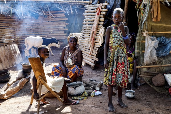 Women and children in the village, a woman preparing a meal surrounded by smoke and traditional ambiance, Brobo, Côte d'Ivoire