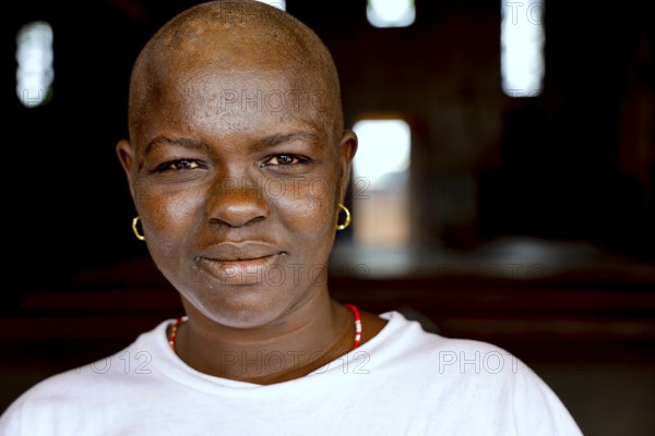 Close-up of smiling woman wearing earrings in relaxed atmosphere, Bouké, region, Côte d'Ivoire