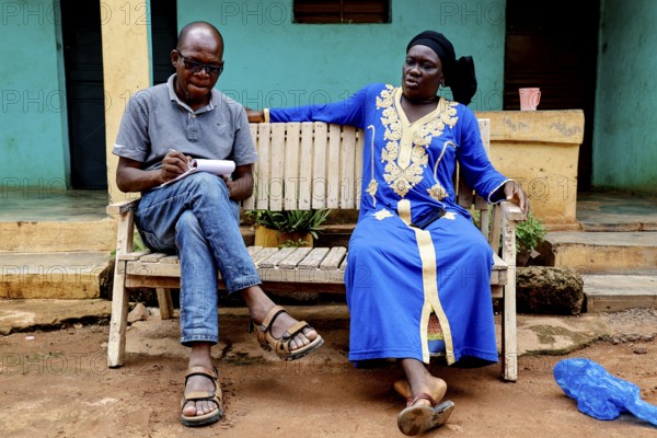 Adama Coulibaly interviews Rokia during a house visit to a bench, Korhogo, CI, Côte d'Ivoire