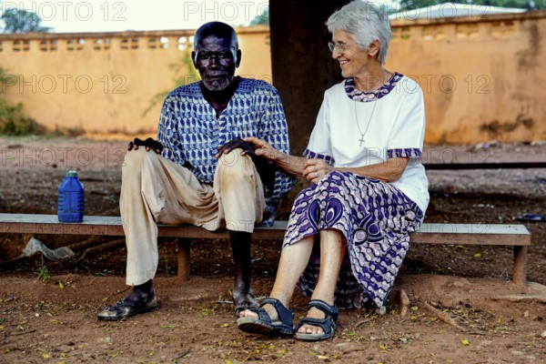 Sr Janine at CI Korhogo in friendly conversation with an outdoor patient, Korhogo, CI, Côte d'Ivoire
