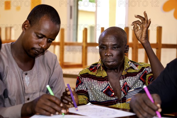 People in CI Korhogo focus on painting therapy with colorful pencils, Korhogo, CI, Côte d'Ivoire