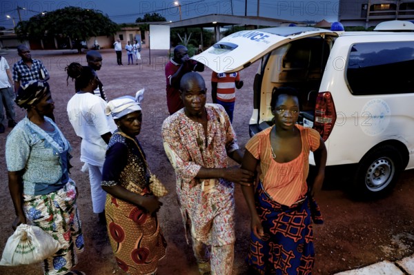 Admissions of a female patient at night, accompanied by several people, White Van in the background, Korhogo, Côte d'Ivoire