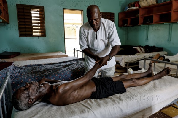 Therapist gives a lying patient a massage at CI Korhogo, Korhogo, CI, Côte d'Ivoire