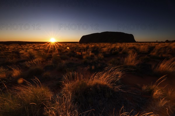 Uluru at sunrise with glowing sky in the Australian outback, Uluru, Northern Territory, Australia