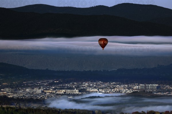 View of Canberra from Mount Ainslie Lookout with a hot air balloon against a mountainous backdrop, Canberra, Australian Capital Territory, Australia