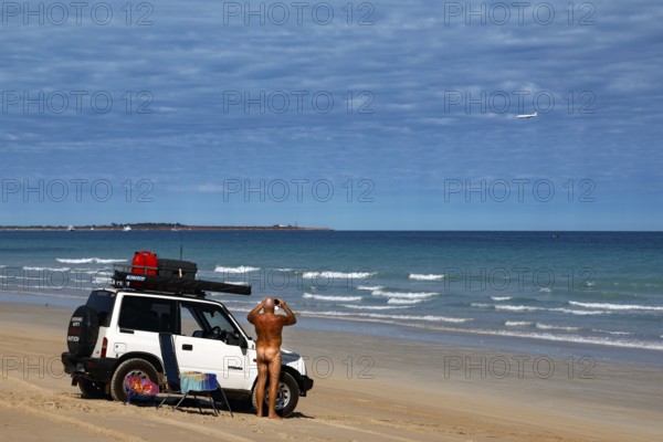 Jeep parked on a wide sandy beach with ocean views in sunny weather, Broome, Western Australia, Australia