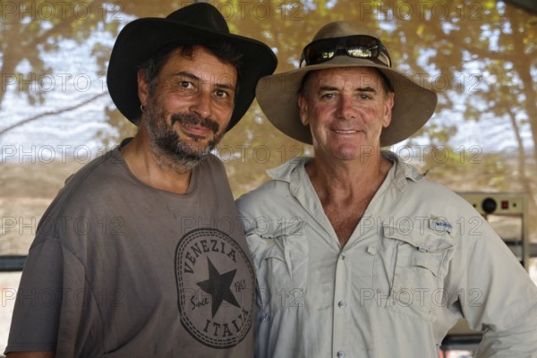 Two men wearing sun hats smiling at camera, Adelaide River, Northern Territory, Australia