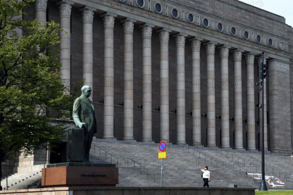 The Finnish Parliament in Helsinki with a statue and impressive pillars, Helsinki, Uusimaa, Finland