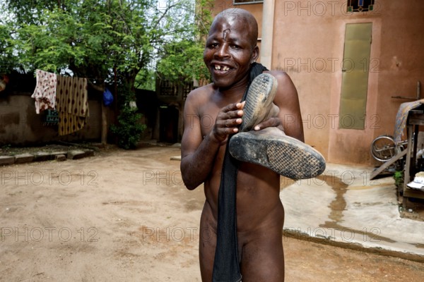 Happy man posing playfully in the courtyard of a psychiatric facility in Bouaké, Bouké, Côte d'Ivoire