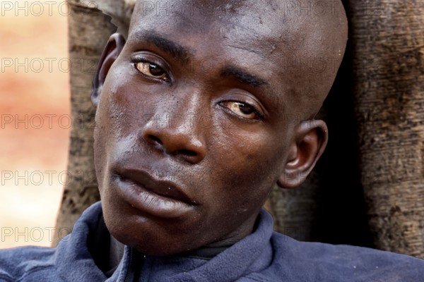 Close-up of an exhausted man outdoors in Bouaké. He seems emotionally burdened, Bouaké, Saint Camille, Nimbo, Côte d'Ivoire