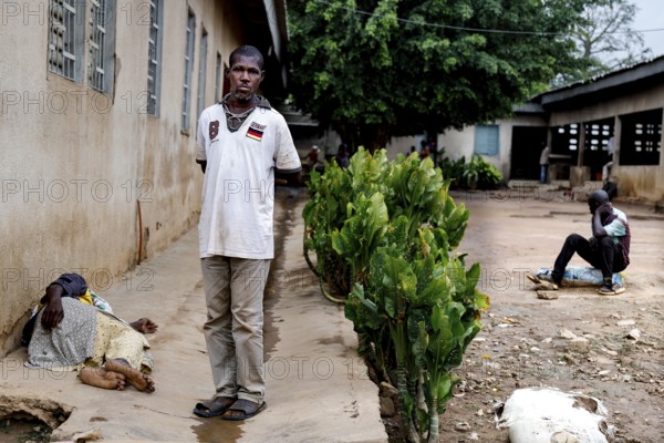 A patient stands outside a men's psychiatry building, Bouaké, Nimbo, Côte d'Ivoire
