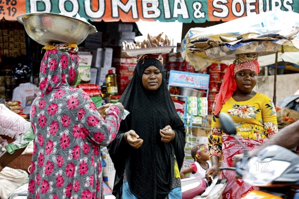 Bustling market with various goods and people in a cheerful atmosphere, CI Bouaké, Ivory Coast