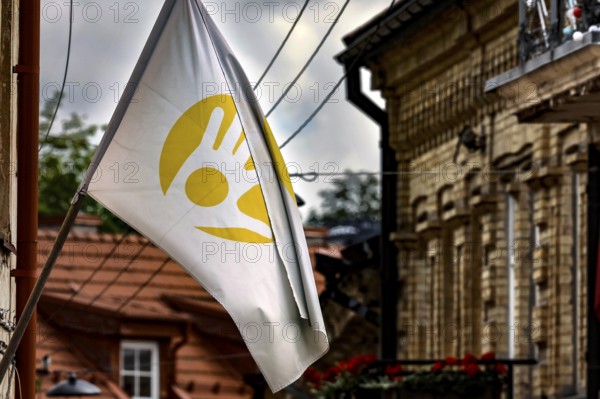 White flag with yellow symbol flying in Uzupis, Vilnius under cloudy sky, Vilnius, Vilnius County, Lithuania