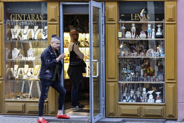 Passers-by enter the jewelry shop on a busy street with a golden façade, Vilnius, Vilnius County, Lithuania