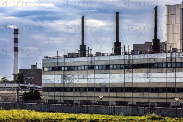 Large disused power plant with several chimneys against a cloudy sky, Visaginas, Lithuania