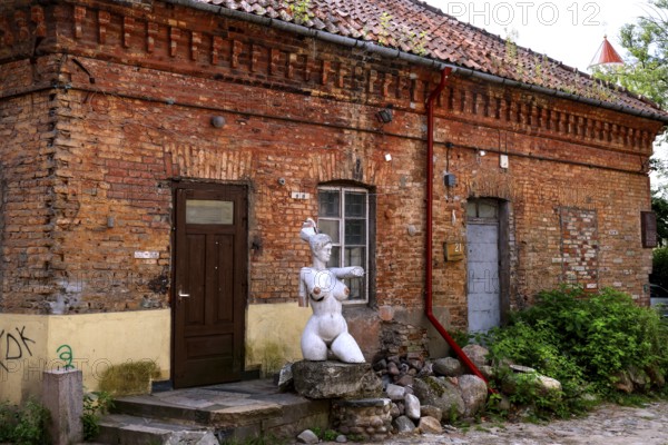 Rustic backyard with brick wall and sculpture in Uzupis, Vilnius, Vilnius County, Lithuania