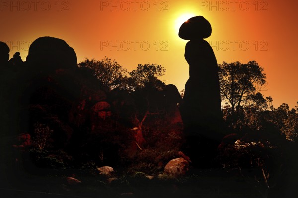Sunrise in the Valley of Wonders with rock formations and tree silhouettes, Babile, Ethiopia