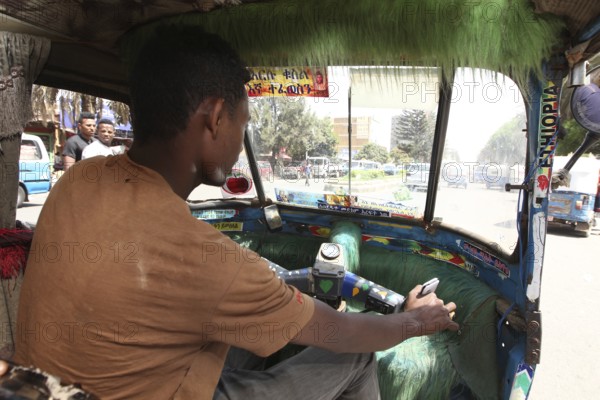 Driver drives a Bajaj taxi in busy city traffic, Bahirdar, Ethiopia