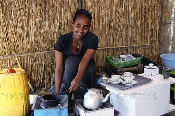 Woman prepares freshly brewed coffee as part of a traditional coffee ceremony in Axum, Axum, Tigray, Ethiopia