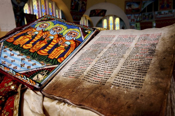 Bible inside St. Mary's Cathedral in Axum shows beautiful stained glass and detailed illuminations, Axum, Ethiopia
