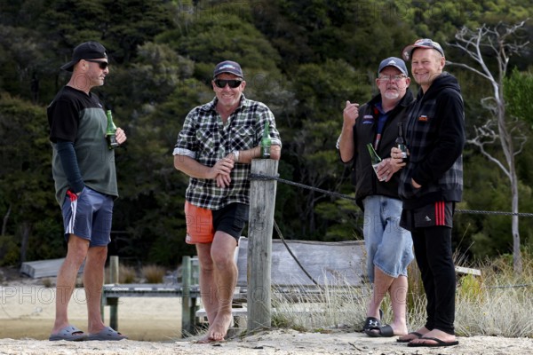 Male group standing on the beach of the Abel Tasman Coast Track, Torrent Bay, Abel Tasman National Park, New Zealand