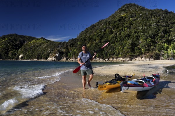 Person kayaking on a beach next to a headland, Adele Island, Abel Tasman National Park, New Zealand