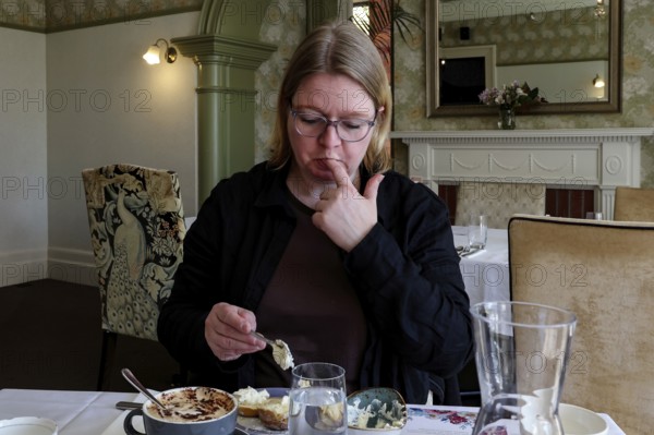 Woman enjoying high tea in elegant setting in Mona Vale, Christchurch, Canterbury, New Zealand
