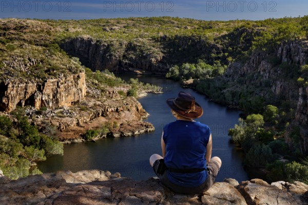 Person sitting on the edge looking at the river in Pat's Lookout, Nitmiluk National Park, Northern Territory, Australia
