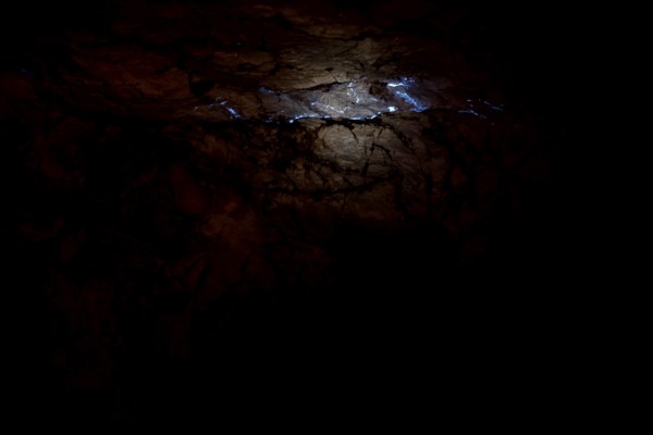 Shiny opalader in a dark layer of rock at Tom's Working Opal Mine, Coober Pedy, South Australia, Australia
