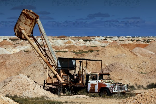 Mining machine in the opal mining area of Coober Pedy, surrounded by desert and blue sky, Coober Pedy, South Australia, Australia