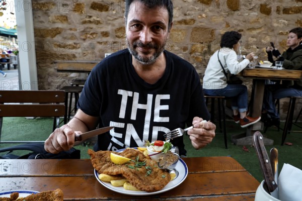 A man enjoying a schnitzel in a German restaurant in Hahndorf, Hahndorf, South Australia, Australia