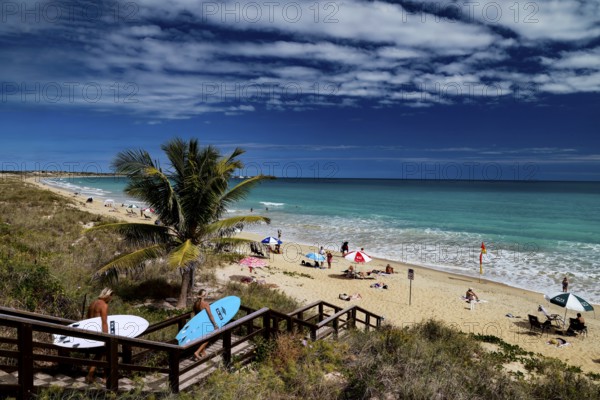 Beach with coconut trees, wooden walkway and colorful umbrellas on Cable Beach, Broome, Western Australia, Australia