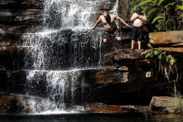 People enjoy refreshment in a waterfall in Galvans Gorge, zero