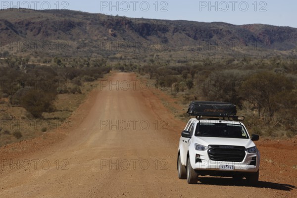 Off-road vehicle on lonely road of Mereenie Loop Road, Mereenie Loop Road, Northern Territory, Australia