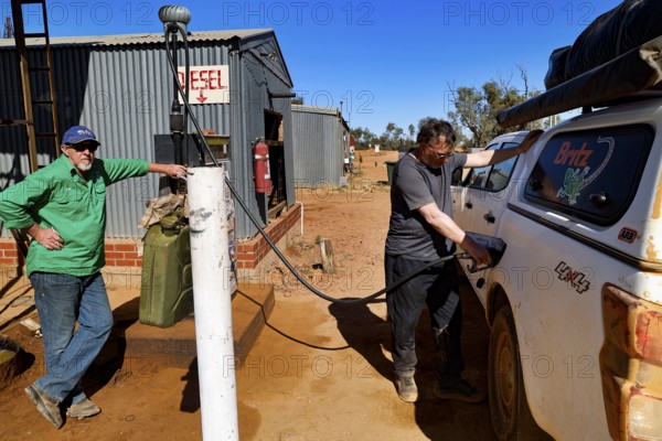 Man refuels a car at the remote Mt Dare Hotel gas station, zero