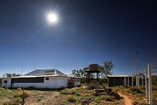 Buildings under bright sun in the barren landscape of Old Andado Station, Old Andado Station, Australia