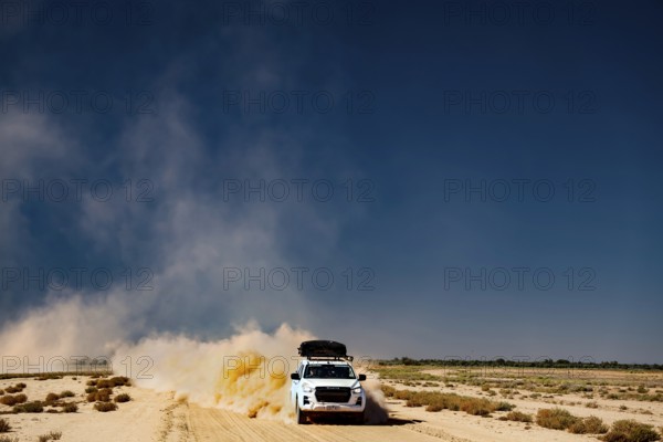 Four-wheel drive vehicle on dusty desert road