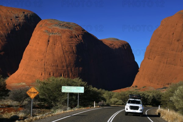 Road in the outback leads through the massive red rocks at Kata Tjuta, Kata Tjuta, Northern Territory, Australia