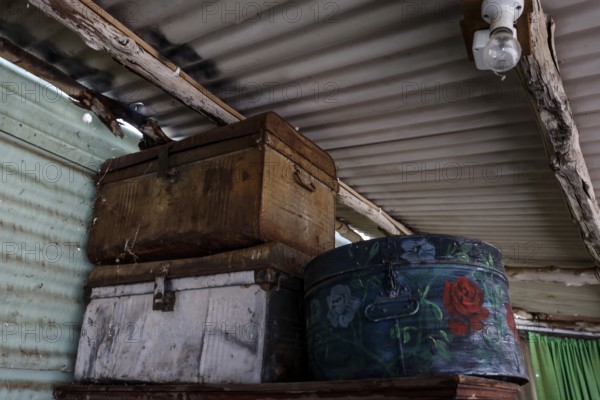 Stacks of old suitcases in a room with metal walls, zero